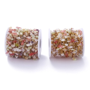 Close-up of bohemian colorful natural stone beaded chain with copper squares on white spools