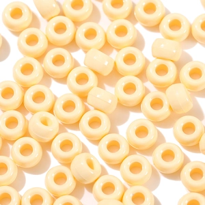 Macro detail of cream-colored acrylic beads with smooth finish and large center holes