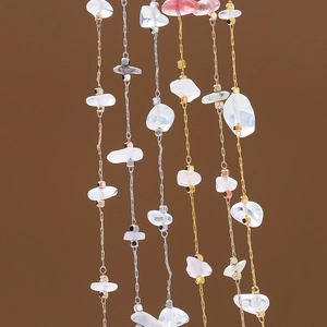 Detailed shot of bohemian natural stone chains with metallic square beads and clear chips