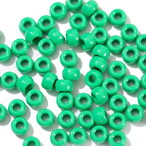 Macro shot of green acrylic barrel pony beads with large holes for DIY jewelry