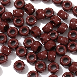 Macro shot of glossy dark brown acrylic pony beads with large holes for DIY crafts
