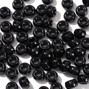 Close-up of bulk black acrylic pony beads with large holes for DIY jewelry making
