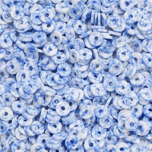 Dettaglio macro di perle in argilla polimerica marmorizzata blu e bianca 6mm per gioielli