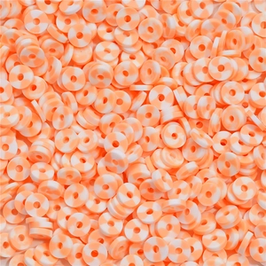 Dettaglio macro di perline Heishi in argilla arancione e bianca per gioielli fai da te