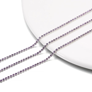 Detail view of 2mm purple crystal rhinestone claw chain with polished silver metal setting