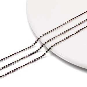 Close-up of 2mm dark red rhinestone claw chain on white ceramic plate for DIY jewelry craft