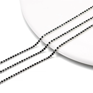 Macro detail of 2mm silver-plated claw chains with black rhinestones for DIY crafts