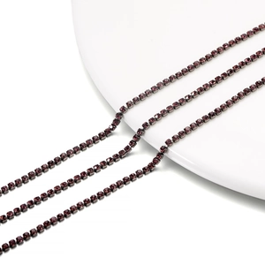 Close-up of deep purple rhinestones in a dark gunmetal claw chain for DIY jewelry