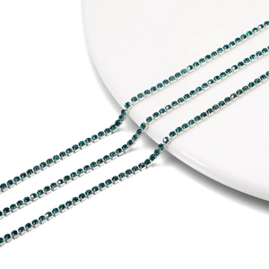 Macro detail of 2mm dark green rhinestone tennis chain with silver-tone claw setting