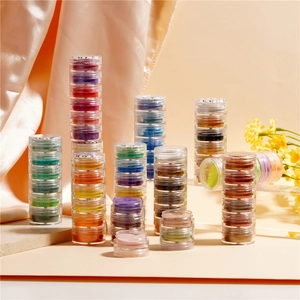 Macro detail of multi-color pearlescent pigment powder set in stacked plastic jars