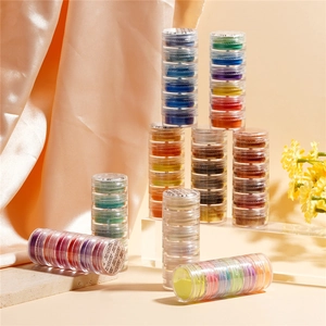 Macro detail of pearlescent nail art glitter powders in stacked transparent jars