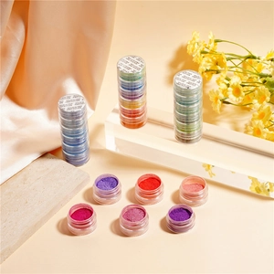 Detailed view of 6-color pearlescent nail glitter set on acrylic stand with satin background