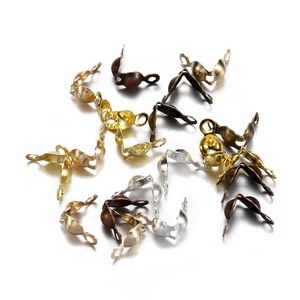 Macro detail of various metallic DIY jewelry fold-over crimp bead covers in multiple colors