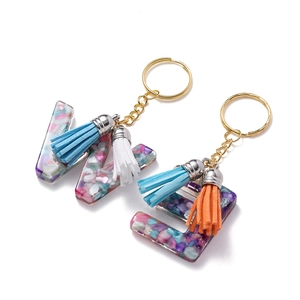 Détail de porte-clés en résine lettres W et E avec pierres colorées et pompons