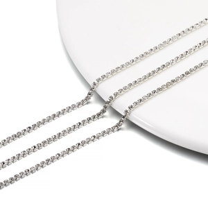 Three rows of premium silver tennis chains with sparkling crystals on a ceramic dish