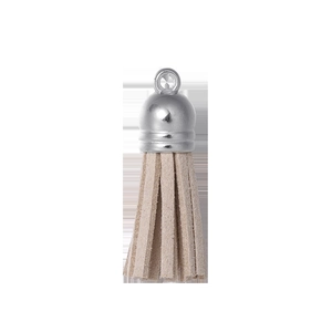 Détail macro du gland en suédine beige avec capuchon argenté pour porte-clés DIY