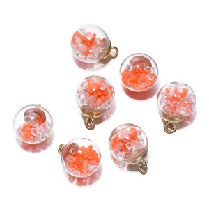 Detail of 6 glowing glass sphere pendants with orange stars for DIY jewelry