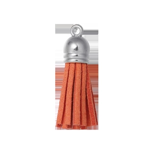 Gros plan d'un pompon en daim orange vif avec capuchon en métal argenté poli