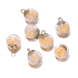 Close-up of glass globe pendants with yellow sequins and beads for DIY jewelry making