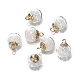 Close-up of luminous glass ball pendants with gold caps for DIY jewelry making