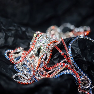 Vibrant 2mm multi-colored rhinestone claw chains with silver setting on black backdrop