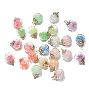 Close-up of colorful luminous glass ball charms with golden metal loops for DIY jewelry