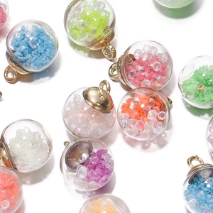 Close-up of colorful luminous glass ball pendants with glitter and gold metal loops