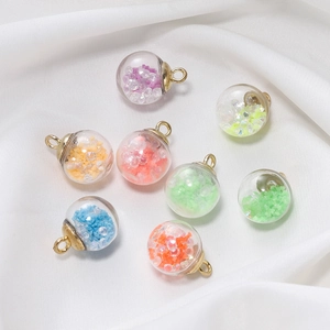 Eight colorful luminous glass ball pendants with gold rings on white silk background