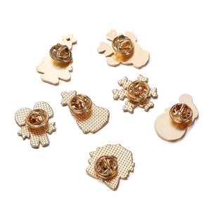Close-up of golden alloy Christmas brooch backings showing butterfly pin clutch fasteners