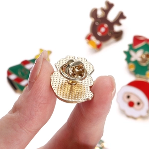 Close-up of golden butterfly clasp on the back of Christmas enamel holiday pins