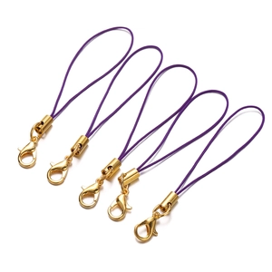 Close-up of five purple braided lanyards with shiny gold lobster clasps for DIY jewelry