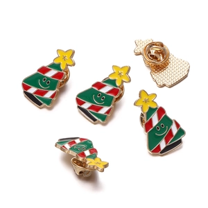 Detail of Christmas tree enamel pins with festive green patterns and butterfly clasp