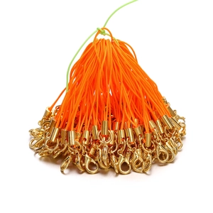 Close-up of orange braided cords with gold lobster clasps for DIY jewelry making