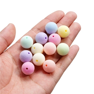 Gros plan de perles rondes floquées macaron avec texture douce tenues dans la main