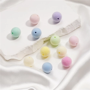 Gros plan de perles floquées aux couleurs macaron avec texture velours pour bijoux DIY