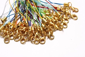 Close-up of colorful DIY lanyard cords with gold lobster clasps in a fan-shaped layout