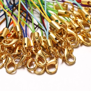 Macro shot of colorful braided phone lanyards with gold lobster clasps for DIY jewelry