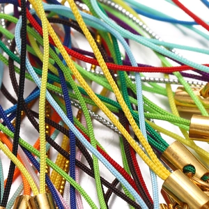 Macro shot of colorful braided lanyards with golden metal caps for DIY jewelry
