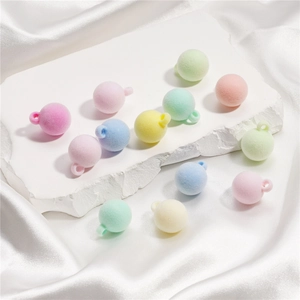 Gros plan de perles floquées aux couleurs macaron avec anneaux pour bijoux DIY et breloques
