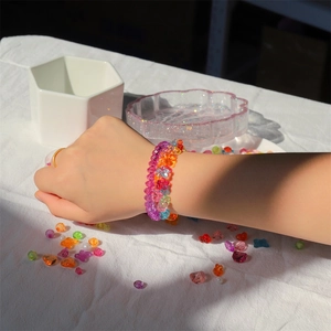 Close-up of colorful DIY beaded bracelets with flower charms and acrylic beads for kids