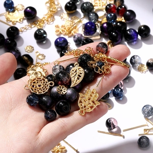 Detail of DIY jewelry kit with blue galaxy beads and gold Fatima hand pendants