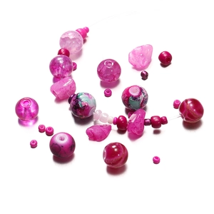 Close-up of pink 8mm glass and acrylic beads with floral patterns for DIY jewelry making
