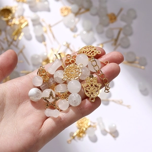Detail of DIY jewelry kit with white moonstone beads and gold celestial metal charms