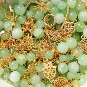 Macro shot of mint green crystal glass beads and gold metal DIY jewelry charms set