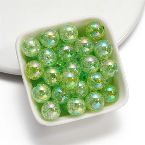Macro shot of 16mm light green crackle glass beads with AB coating in a small white bowl
