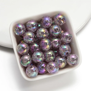 Macro shot of 16mm purple crackle acrylic beads with iridescent finish in a white bowl