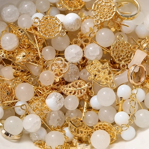 Macro view of gold metal charms and white crystal beads set for DIY jewelry making