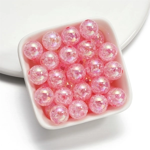 Macro shot of 16mm pink iridescent crackle glass beads inside a white ceramic bowl