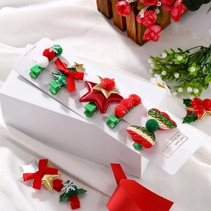 Detail of Christmas hair clip set featuring glitter stars and plush tree ornaments