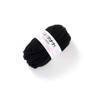 Detailed close-up of black 4-ply milk cotton yarn ball with LILIARGE brand label